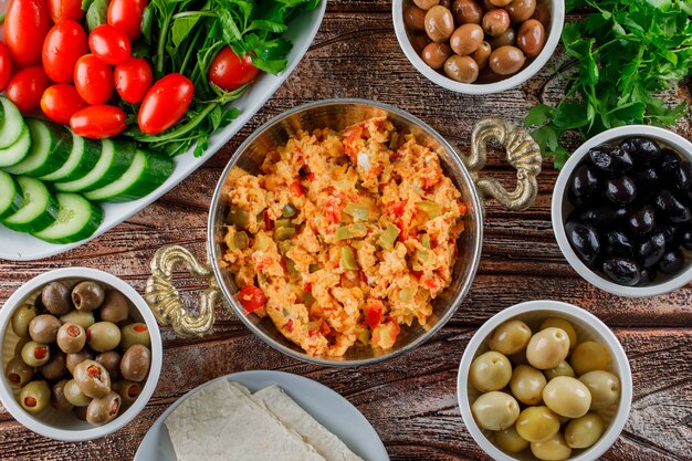 Draufsicht köstliche Mahlzeit im Topf mit Salat, Gurken in Schalen auf Holzoberfläche