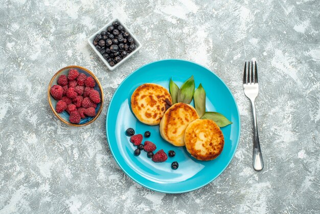 Draufsicht köstliche Muffins mit Beeren auf hellem Hintergrund