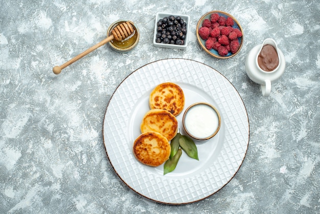 Kostenloses Foto draufsicht köstliche muffins mit beeren auf hellem hintergrund