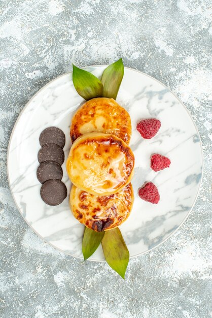 Draufsicht köstliche Muffins mit Honig und Schokokeksen auf hellem Hintergrund