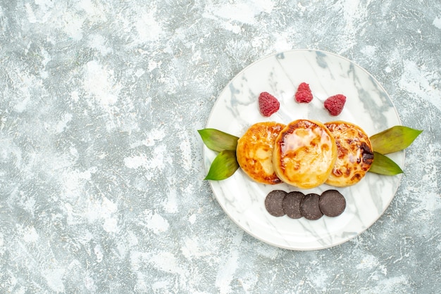 Draufsicht köstliche Muffins mit Honig und Schokokeksen auf hellem Hintergrund