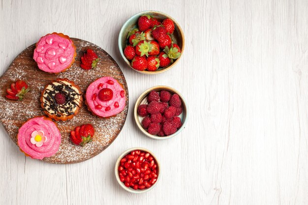 Draufsicht köstliche Obstkuchen cremige Desserts mit Früchten und Beeren auf weißem Hintergrund Sahnetee süßer Kuchen Cookie Dessert