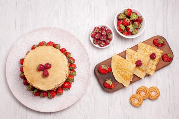 Draufsicht köstliche Pfannkuchen mit Erdbeeren auf weißem Hintergrund Obstkuchen Kuchen Keks süße Beere