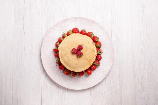 Draufsicht köstliche Pfannkuchen mit frischen roten Erdbeeren auf weißem Hintergrund Obstkuchen Beerenkuchen süßer Kekszucker