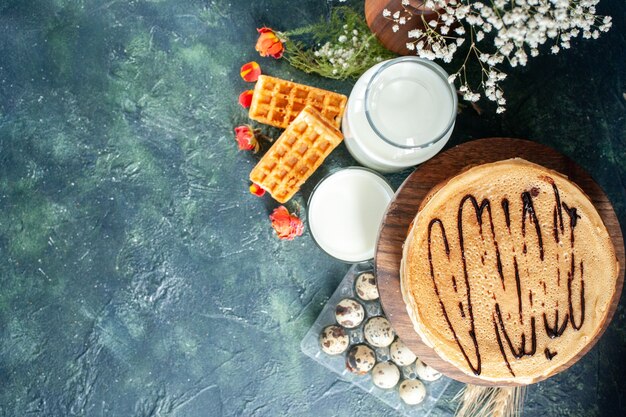 Draufsicht köstliche Pfannkuchen mit frischer Milch auf einer dunkelblauen Oberfläche