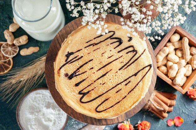 Draufsicht köstliche Pfannkuchen mit Milch und Nüssen auf dunkelblauer Oberfläche