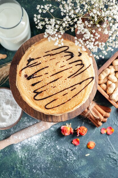 Draufsicht köstliche Pfannkuchen mit Milch und Nüssen auf dunkelblauer Oberfläche