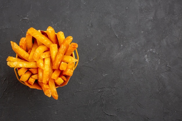 Draufsicht köstliche Pommes Frites im Paket auf dunklem Hintergrund Fast-Food-Kartoffelgericht Burger-Mahlzeit