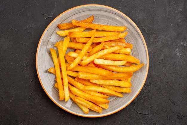 Draufsicht köstliche Pommes frites im Teller auf dunklem Hintergrund Kartoffel-Burger-Mahlzeit-Sandwich-Abendessen-Gericht