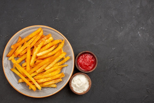 Draufsicht köstliche Pommes frites im Teller auf dunklem Hintergrund Kartoffeln Mahlzeit Sandwich Gericht Burger Fastfood