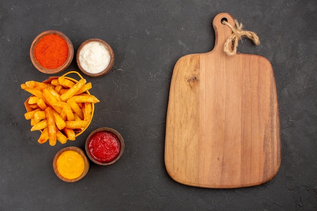 Draufsicht köstliche Pommes frites mit Soßen auf dem dunklen Hintergrundgericht Burger-Fast-Food-Kartoffelmahlzeit