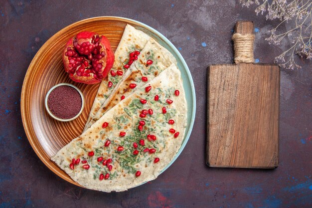 Draufsicht köstliche qutabs gekochte Teigstücke mit Grüns auf der dunklen Oberfläche Teigmahlzeit Abendessen Gericht kochen