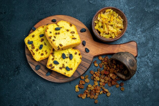 Draufsicht köstliche Rosinenkuchen, die mit frischen Rosinen auf dunkelblauem Raum geschnitten werden