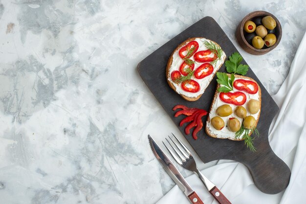 Draufsicht köstliche Sandwiches mit Paprika und Oliven auf Schneidebrett weißer Hintergrund Mittagessen Brot Sandwich horizontale Mahlzeit Burger