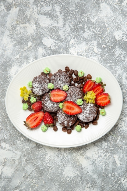 Draufsicht köstliche Schokoladenkuchen mit frischen Erdbeeren auf weißer Oberfläche Kekszuckerkuchen süßer Tee-Keks