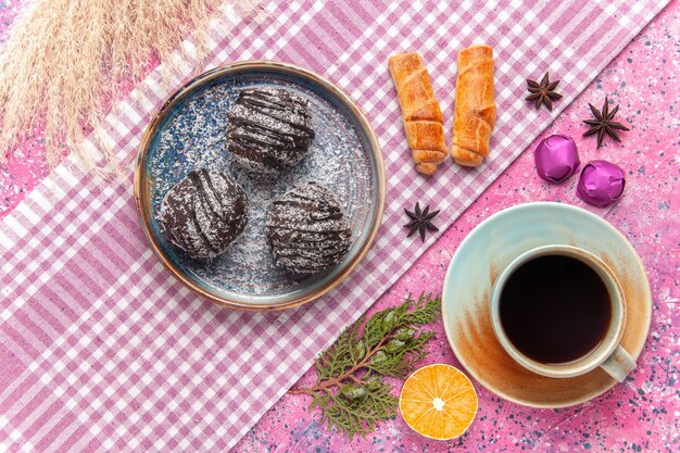 Draufsicht köstliche Schokoladenkuchen mit Tasse Tee auf Rosa