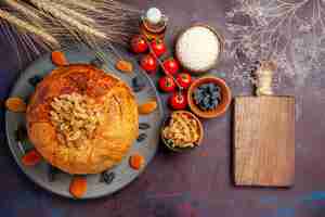 Kostenloses Foto draufsicht köstliche shakh plov gekochte reismahlzeit mit rosinen und tomaten auf dunkelviolettem hintergrundmahlzeitteig, der reisdinner kocht