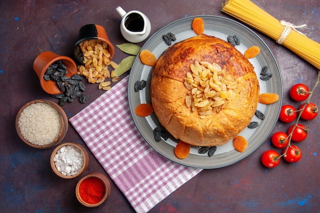 Draufsicht köstliche shakh plov östliche Mahlzeit besteht aus gekochtem Reis innerhalb des runden Teigs auf dunklem Bodenteigmahlzeitnahrungsmittelreis