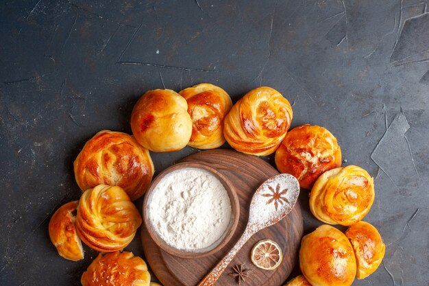 Draufsicht köstliche süße Brötchen auf dunklem Hintergrund