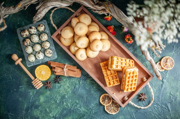 Draufsicht köstliche süße Kekse mit kleinen Kuchen auf dunkler Oberfläche