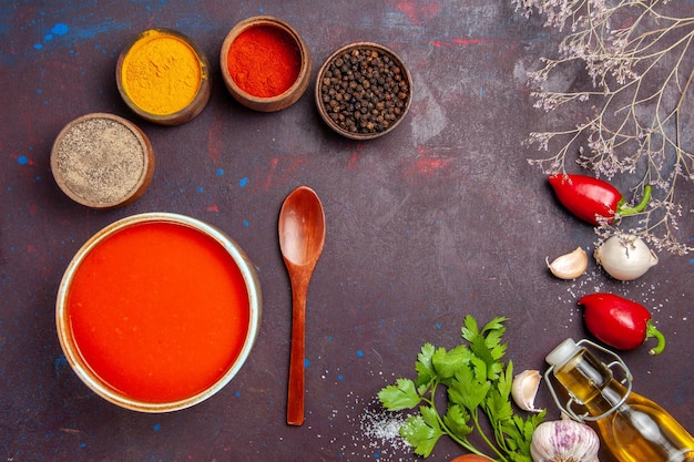 Draufsicht köstliche Tomatensuppe gekocht aus frischen Tomaten mit Gewürzen auf dunklem Hintergrund Tomatengericht Suppe Soße Mahlzeit rot