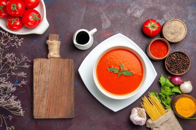 Draufsicht köstliche Tomatensuppe mit frischen Tomaten und Gewürzen auf dem dunklen Hintergrund Gericht Mahlzeit Sauce Tomatenfarbe Suppe