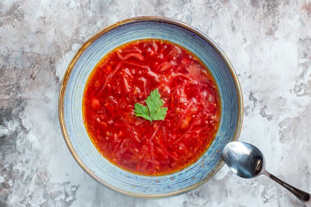 Draufsicht köstliche ukrainische Rübensuppe des Borschtsches innerhalb des Tellers auf weißem Hintergrund