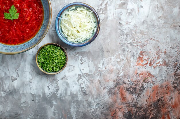 Draufsicht köstliche ukrainische Rübensuppe des Borschtsches mit frischem Kohl und Grüns auf weißem Hintergrund