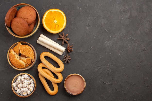 Kostenloses Foto draufsicht köstliche zuckerkekse mit süßen crackern auf dunklem hintergrund cookie keks zuckerkuchen dessert süß