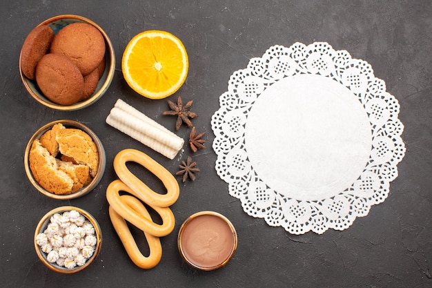 Draufsicht köstliche Zuckerkekse mit süßen Crackern auf dunklem Hintergrund Kekse Keks Zuckerkuchen Dessert süß