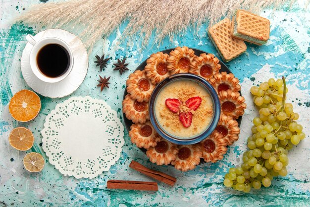 Draufsicht köstliche Zuckerkekse mit Waffeln Tasse Kaffee und Erdbeerdessert auf dem blauen Schreibtisch