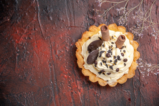 Draufsicht köstlicher cremiger kuchen auf dunklem tischdessert süßem kuchen