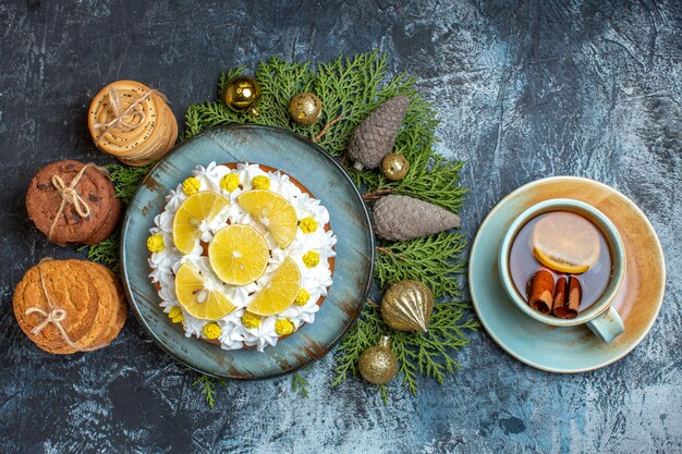 Draufsicht köstlicher cremiger Kuchen mit Keksen und Tasse Tee