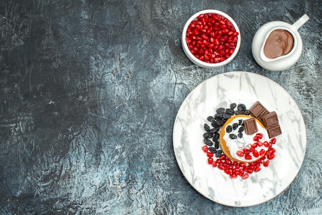 Draufsicht köstlicher cremiger Kuchen mit Schokolade und Rosinen auf hell-dunklem Hintergrund