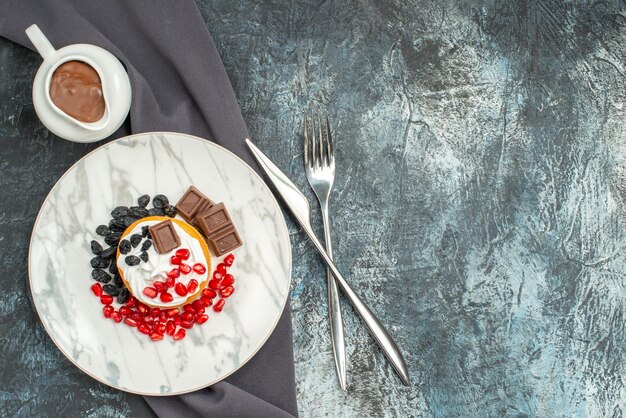 Draufsicht köstlicher cremiger Kuchen mit Schokolade und Rosinen auf hell-dunklem Hintergrund