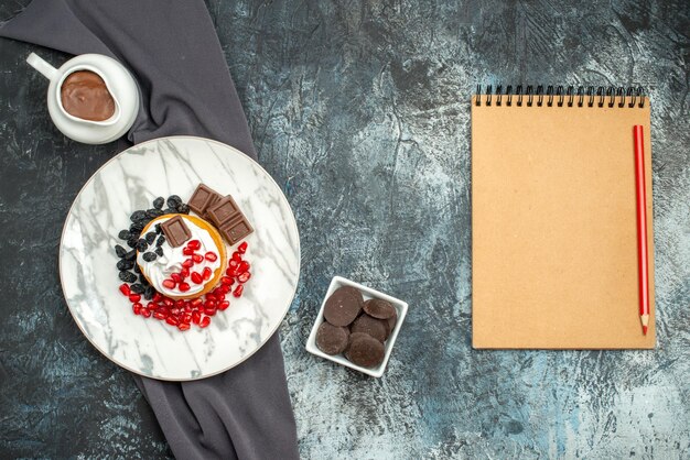 Draufsicht köstlicher cremiger Kuchen mit Schokolade und Rosinen auf hell-dunklem Schreibtisch Dessert Zuckerkeks Keks süß