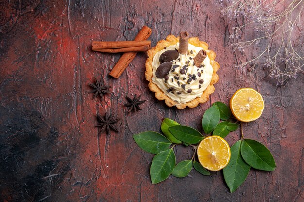 Draufsicht köstlicher cremiger Kuchen mit Zitrone auf dunklem Tischdessert süßer Kekskuchen