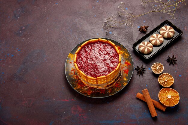 Draufsicht köstlicher Dessertkuchen mit Tasse Kaffee und Schokoladenplätzchen auf dunklem Schreibtischkekszuckerplätzchenkuchendessert süß