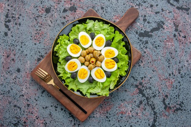 Draufsicht köstlicher Eiersalat grüner Salat und Oliven auf hellem Hintergrund