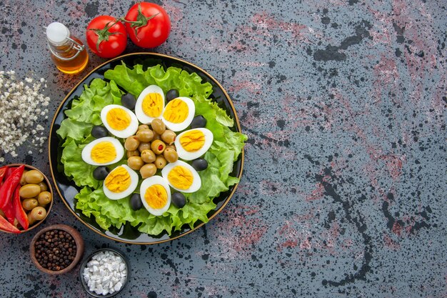 Draufsicht köstlicher Eiersalat mit Tomaten und Oliven auf hellem Hintergrund