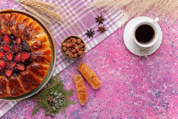 Draufsicht köstlicher Erdbeerkuchen fruchtiger Kuchen mit Tasse Tee auf dem Rosa