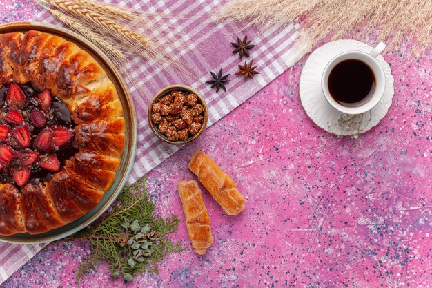 Draufsicht köstlicher Erdbeerkuchen fruchtiger Kuchen mit Tasse Tee auf dem Rosa