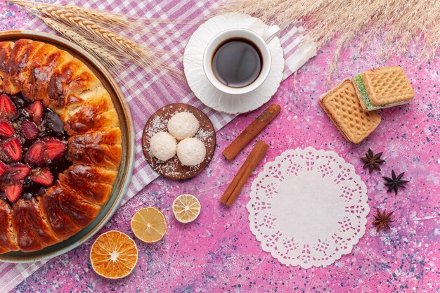 Draufsicht köstlicher Erdbeerkuchen fruchtiger Kuchen mit Tasse Tee auf dem Rosa