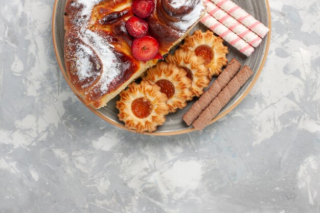 Draufsicht köstlicher Erdbeerkuchen mit Keksen und kleinen Kuchen auf hellweißem Oberflächenkekszuckerkuchen süßem Kuchenplätzchen