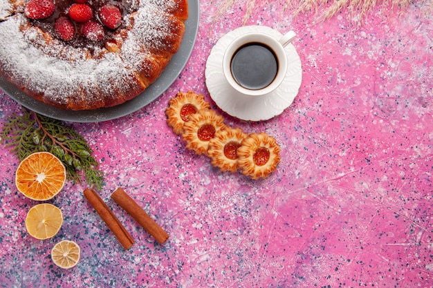 Draufsicht köstlicher Erdbeerkuchen mit Keksen und Tasse Tee auf dem rosa Hintergrundkuchen backen süßen Zuckerkeksplätzchenfarbkuchen