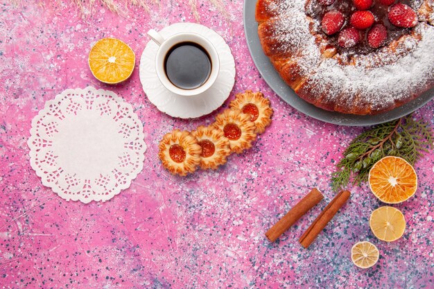 Draufsicht köstlicher Erdbeerkuchen mit Keksen und Tasse Tee auf rosa Schreibtischkuchen backen süßen Zuckerkeksplätzchenfarbkuchen