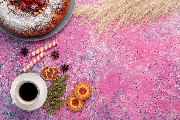 Draufsicht köstlicher Erdbeerkuchen mit Keksen und Tasse Tee auf rosa Schreibtischkuchen süßer Zuckerplätzchenkuchen