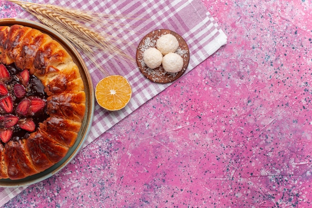 Draufsicht köstlicher erdbeerkuchen runder geformter fruchtiger kuchen auf dem rosa