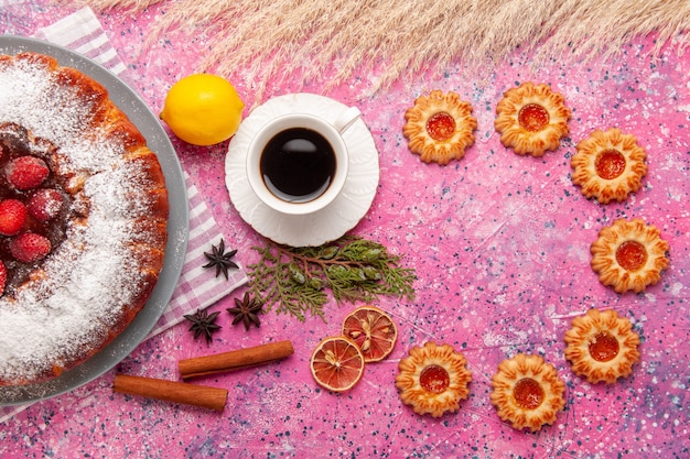 Draufsicht köstlicher Erdbeerkuchenzucker pulverisiert mit Keksen und Tee auf dem hellrosa Hintergrundkuchen süßer Zuckerkeksplätzchentee