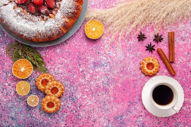 Draufsicht köstlicher Erdbeerkuchenzuckerpulverkuchen mit Keksen und Tasse Tee auf rosa Hintergrundkuchen süßer Zuckerkeksplätzchenkuchen